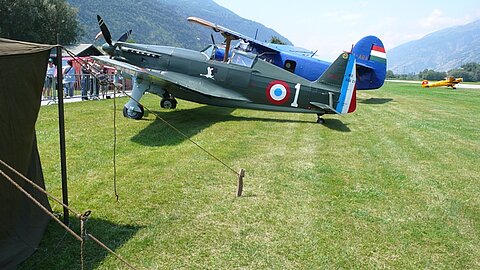 Hinter diesem franz. Morane handelt es sich um ein ehemaliges Schweizer Militärflugzeug.